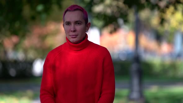 Alone Man with Pink Hair Dressed In Red Sweater Is Walking in City at Autumn or Spring, Medium