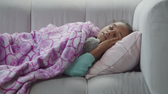 Little Cute Black Girl Sleeping with Toy on Sofa