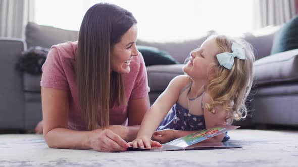 Caucasian mother and daughter having fun reading book