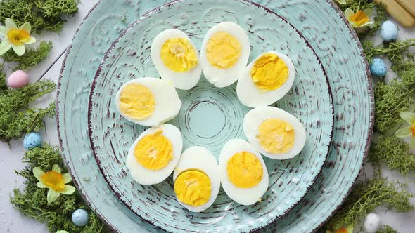 Easter Table Setting with Flowers and Eggs. Decorative Plates with Boiled Eggs