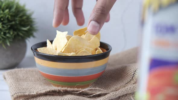 Hand Pick Tasty Potato Chips From a Bowl