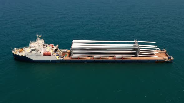 Heavy load carrier ship loaded with Electric Turbine Blades anchored at Sea.