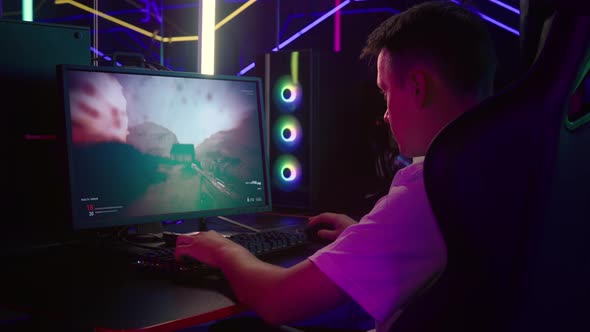 Young Gamer Playing Level In Difficult Military FPS Computer Video Game alt