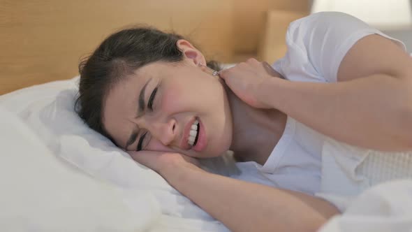 Young Indian Woman having Neck Pain while Sleeping in Bed