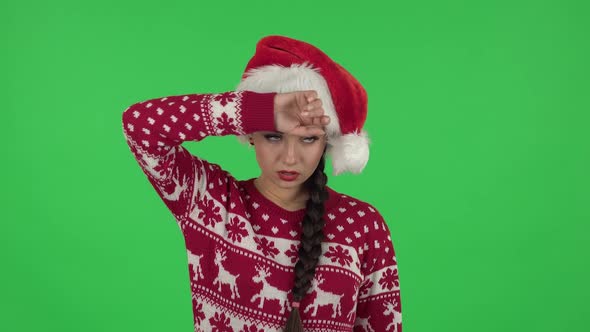 Portrait of Sweety Girl in Santa Claus Hat Is Upset and Tired. Green Screen