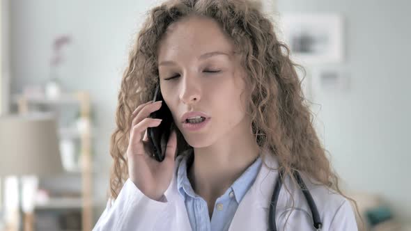 Young Lady Doctor Talking with Patient on Phone