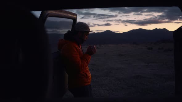 Man on Camping Trip Drink at Sunset Near Van