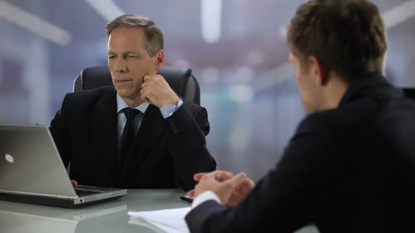 Employer Looking at Laptop Screen Listening Young Candidate During Job Interview