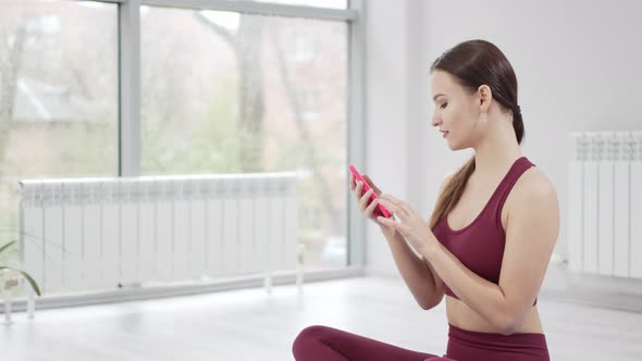 a Young Woman with Laptop Sends a Message to Students for an Online Workout