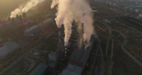 High Pollution From smoking smokestacks of industrial plant. Black smoke against setting sun