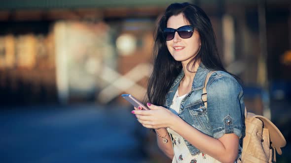 Attractive Woman with Smart Phone Typing a Text Message in a Street Cafe