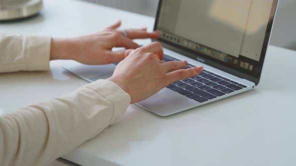Female hands typing on a laptop on the desk