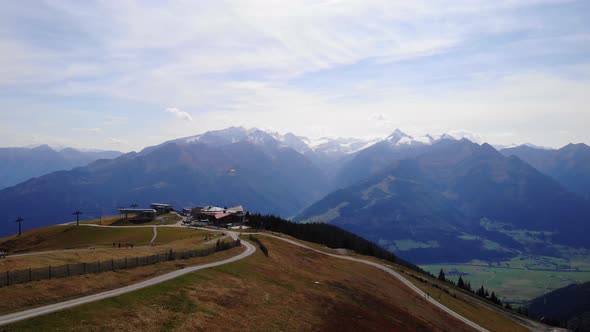 Tourist Paraglides Over Mount Schmitten With A View Of Kitzbuhel Alps In Austria. ascending drone sh