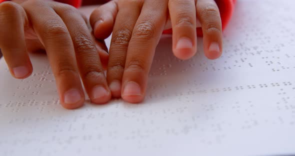 Close-up of blind Asian schoolboy hand reading a braille book in classroom at school 4k