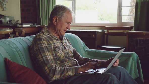 Senior man using laptop at home