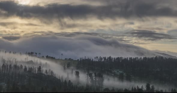 Timelapse of Evening Sun Rays Emerging Through the Cold Foggy Clouds in the Mountains