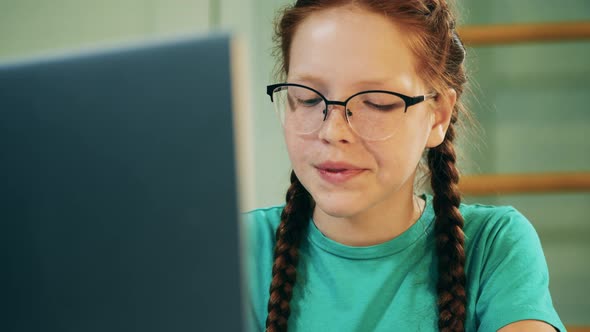 Teenage Girl in Glasses is Talking During Her Online Class