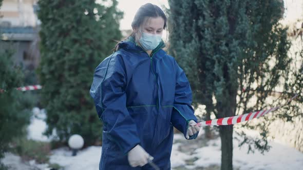 Caucasian Woman Cutting Warning Tape with Scissors Standing at Crime Scene and Looking at Camera