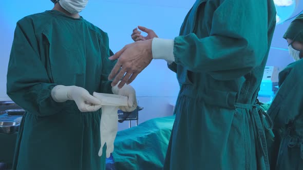 Doctor with uniform preparing a glove for a operation