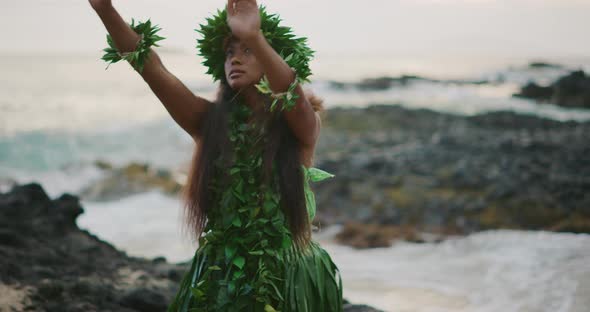 Woman performing traditional Hawaiian hula by the ocean alt