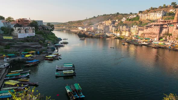 Time lapse: Omkareshwar cityscape, India, sacred hindu temple. Holy Narmada River, boats floating