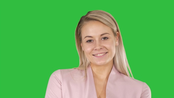 Portrait of a smiling blond woman on a Green Screen, Chroma Key.