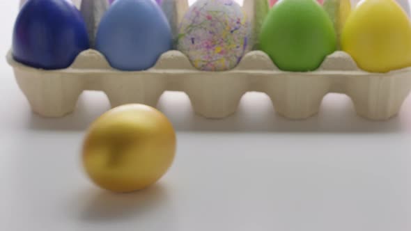 Easter Colourful Eggs Rolling on a White Table