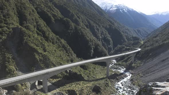 Cars driving across a viaduct in in the mountains of New Zealand