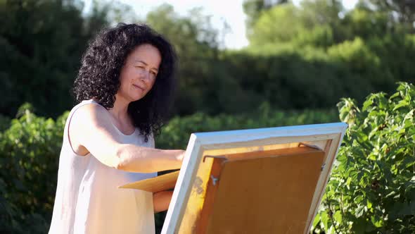 Female Artist Painting a Colorful Painting Outdoors