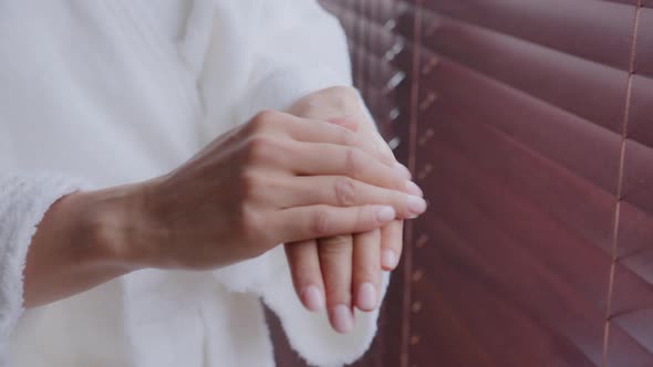 Closeup Female Hands Unrecognizable Young Healthy Woman in Bathrobe Applies Moisturizer Treats Skin