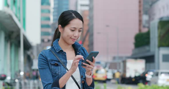 Woman work on mobile phone in city at city park