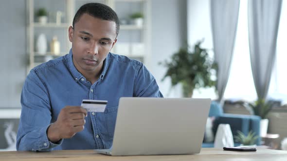 Online Shopping on Laptop by Young African Man