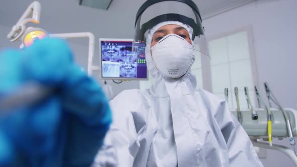 Patient Pov While Dentist in Protective Suit Against Covid Examining