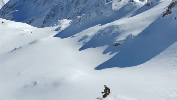 A man skiing on powder snow covered mountains