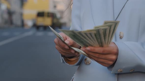 Closeup Female Hands Counting Dollar Bills Outdoors Standing on Traffic Road