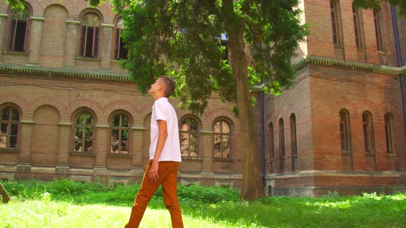 Boy Walking Near the Building