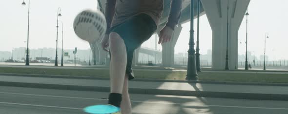 Male Soccer Athlete Juggling Ball in City