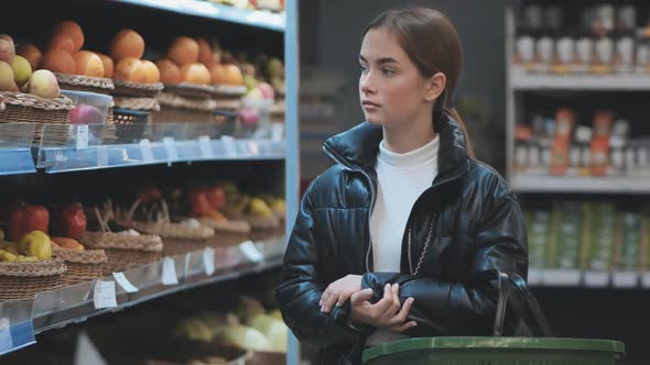 A Young Girl Choosing Fruit at the Store