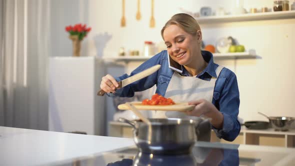 Young Woman Talking on Phone and Preparing Tomato Sauce, Easy Food Recipe