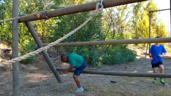 Boys crossing the rope during obstacle course