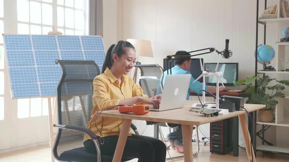 Asian Woman And Man With Solar Cell Panel Working With Computer At The Office