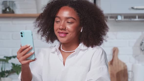Cheerful Young African American Woman Waves and Smiles During Video Call