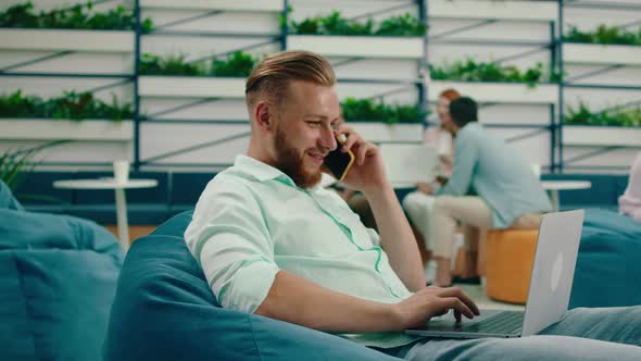 A Man in a Bean Bag Coffee Area in an Office is