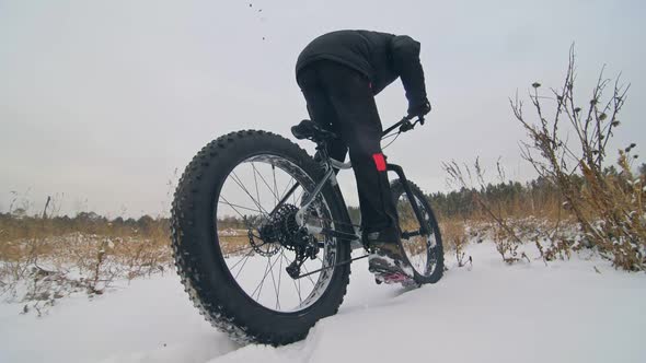 Professional Extreme Sportsman Biker Riding Fat Bike in Outdoor. Close-up View of Rear Wheel