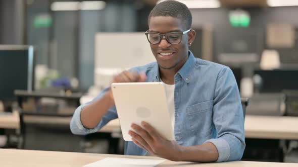 Video Call on Tablet By Young African American Man in Office