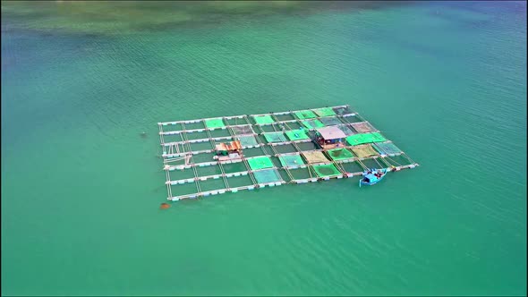 Close Aerial Motion Around Floating Farm with House Boat