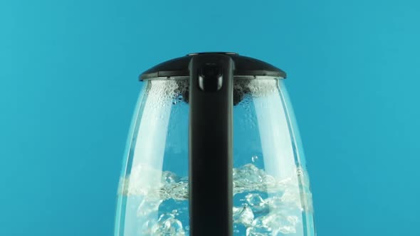 An Electric Kettle with Transparent Walls. Process of Boiling. Blue Background