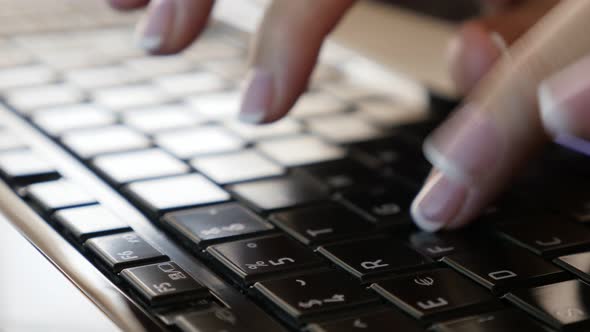 Female fingers typing on black laptop keyboard keys close-up tilting 4K 2160p 30fps UltraHD video - 