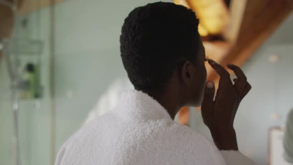 African american attractive woman taking care of face in bathroom