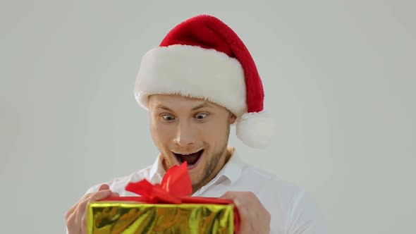 Portrait of a beautiful man in Santa's hat with a fun face image, white background